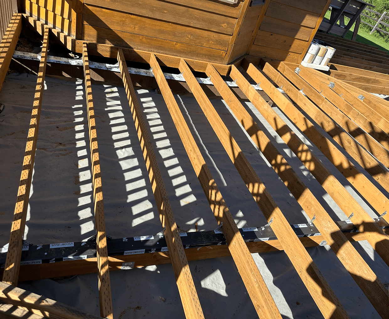 Wooden deck construction with exposed beams.
